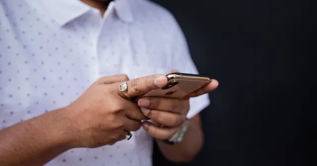 Pessoa segurando o celular com as duas mãos