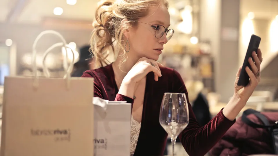 Consumidora conferindo o celular depois das compras