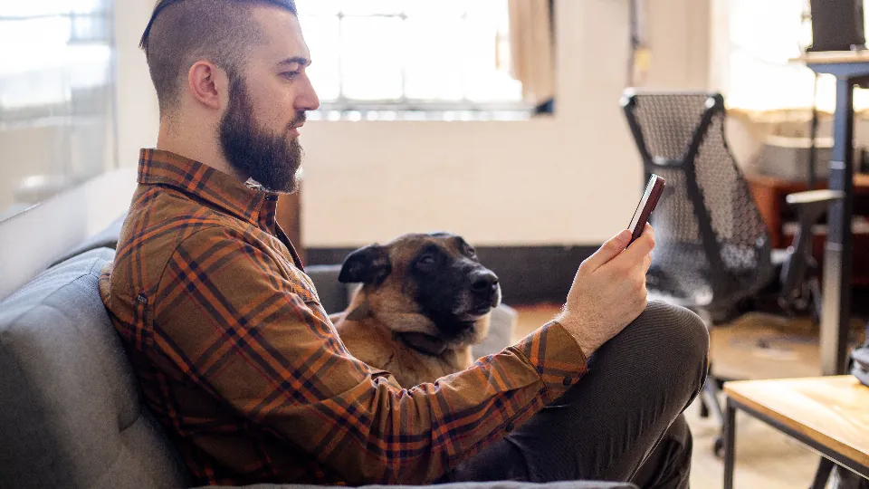 Homem no sofá trocando mensagens pelo celular